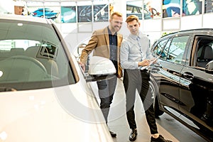 Affable handsome consultant and client in dealership