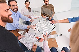 Affable man giving forms to people