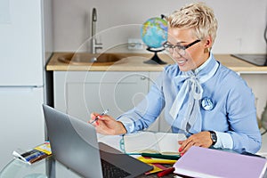 Affable pleased tutor work on laptop, hold lessons online