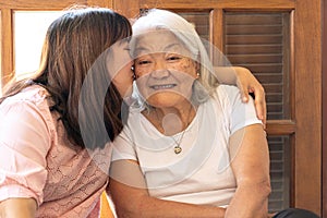 Affectionate Asian daughter kissing her mother at home. Mother\'s Day
