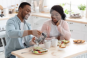 Affectionate Black Couple Eating Tasty Breakfast And Drinking Coffee In Kitchen