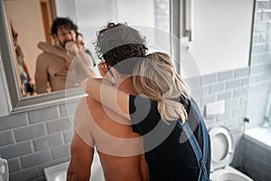 Affectionate couple brushing teeth together