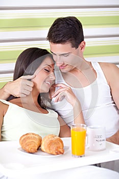 Affectionate couple having breakfast in bed