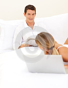 Affectionate couple relaxing on their bed