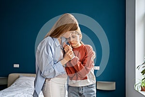 Affectionate empathic young mom tender embracing calming sad upset teen daughter.