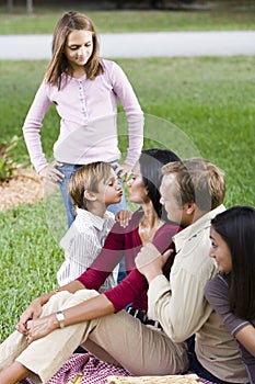 Affectionate family of five together in park photo