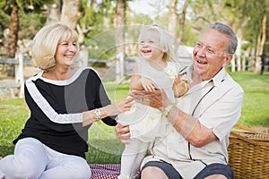 Affectionate Granddaughter and Grandparents Playing At The Park