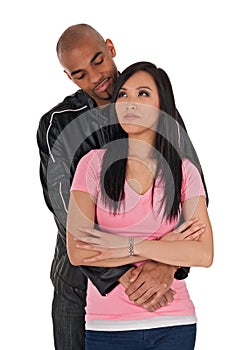 Affectionate guy embracing sceptical-looking girl photo