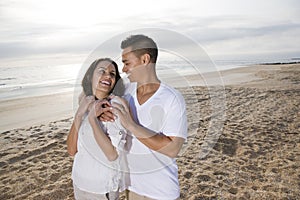 Affectionate Hispanic couple standing on beach photo