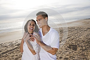 Affectionate Hispanic couple standing on beach