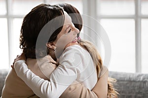 Affectionate loving 60s old woman cuddling grown up daughter.