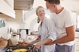 Affectionate Mature Couple Prepare Breakfast In Kitchen Together