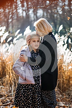 Affectionate Moment Between Mother and Daughter Outdoors. A tender scene of a mother kissing her daughter on the head in