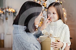 Affectionate mother gives present to her adorble little daughter