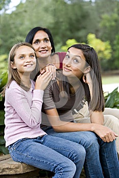 Affectionate mother and two daughters smiling