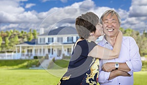 Affectionate Senior Chinese Couple In Front of Beautiful House