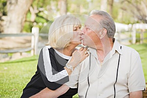 Affectionate Senior Couple Kissing At The Park