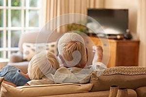 Affectionate senior couple watching television together on their sofa