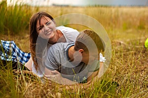 Affectionate young couple hugging in sunny rural field.