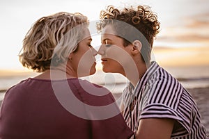 Affectionate young lesbian couple enjoying a romantic beach sunset together