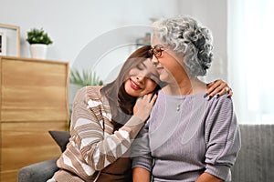 Affectionate young woman embracing happy senior mother expressing unconditional love