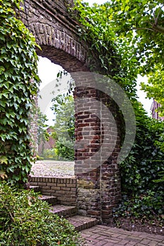 Afferden, Limburg, Netherlands - May 20, 2020: Old overgrown entrance gate as entrance to the local cemetery