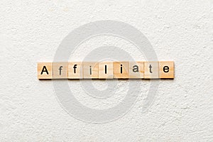 AFFILIATE word written on wood block. AFFILIATE text on cement table for your desing, concept