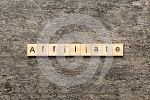 AFFILIATE word written on wood block. AFFILIATE text on cement table for your desing, concept
