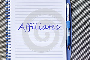 Affiliates write on notebook photo