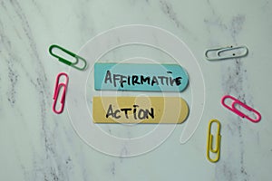 Affirmative Action write on sticky notes isolated on office desk