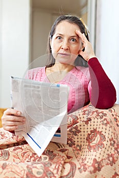 Affliction mature woman with newspaper