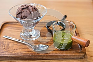 Affogato chocolate ice cream with green tea hot fudge on wood table photo