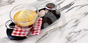 Affogato coffee dessert, Cup of vanilla ice cream with espresso and tea spoon putting on red plaid cotton with stainless mug