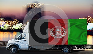 Afghanistan flag on the side of a white van against the backdrop of a blurred city and river. Logistics concept