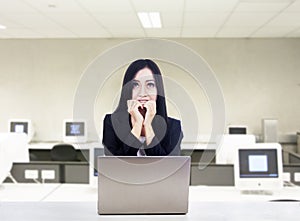 Afraid businesswoman with laptop at office