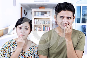 Afraid couple biting nails at home