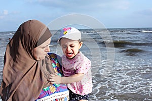 Afraid crying arab muslim baby girl with her mother