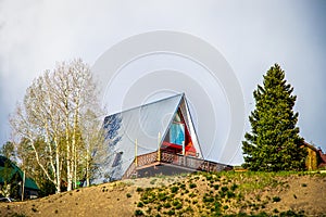 Aframe house on top of hill with aspen and evergreen trees in ski resort village in Colorado USA
