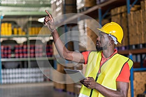 Africa American workers using tablets and checks goods in the automotive parts warehouse distribution center. Male engineers