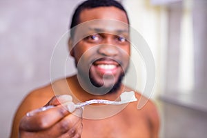 africa man toothbrush in bathroom looking at mirror