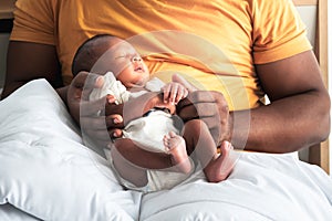 African 12-day-old baby black skin newborn son, sleeping with his father