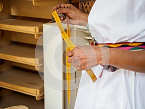 african adult seamstress artisan Measure customer with tape for cloth desgin tailoring in workshop