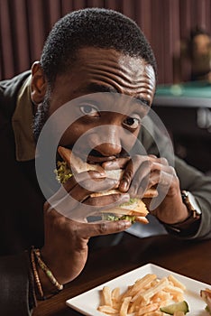 african amercian man eating sandwich