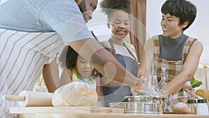 African America family wearing apron thresh flour for cooking bakery or bread together in the kitchen at home.