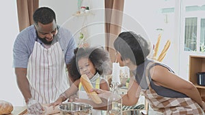 African America family wearing apron thresh flour for cooking and dancing and song together in the kitchen.