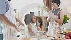 African America family wearing apron thresh flour for cooking and dancing and song together in the kitchen.