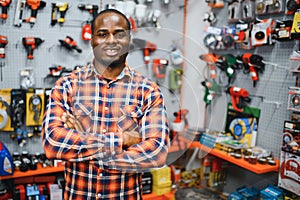 African americam man buying modern electric drill while standing in tool. Hardware construction site objects concept