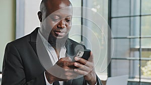 African american adult businessman bearded male employee chatting in cell app hold mobile phone upload business