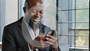 African american adult businessman bearded male employee chatting in cell app hold mobile phone upload business