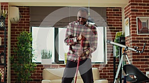 African american adult mopping living room wooden floors and dancing